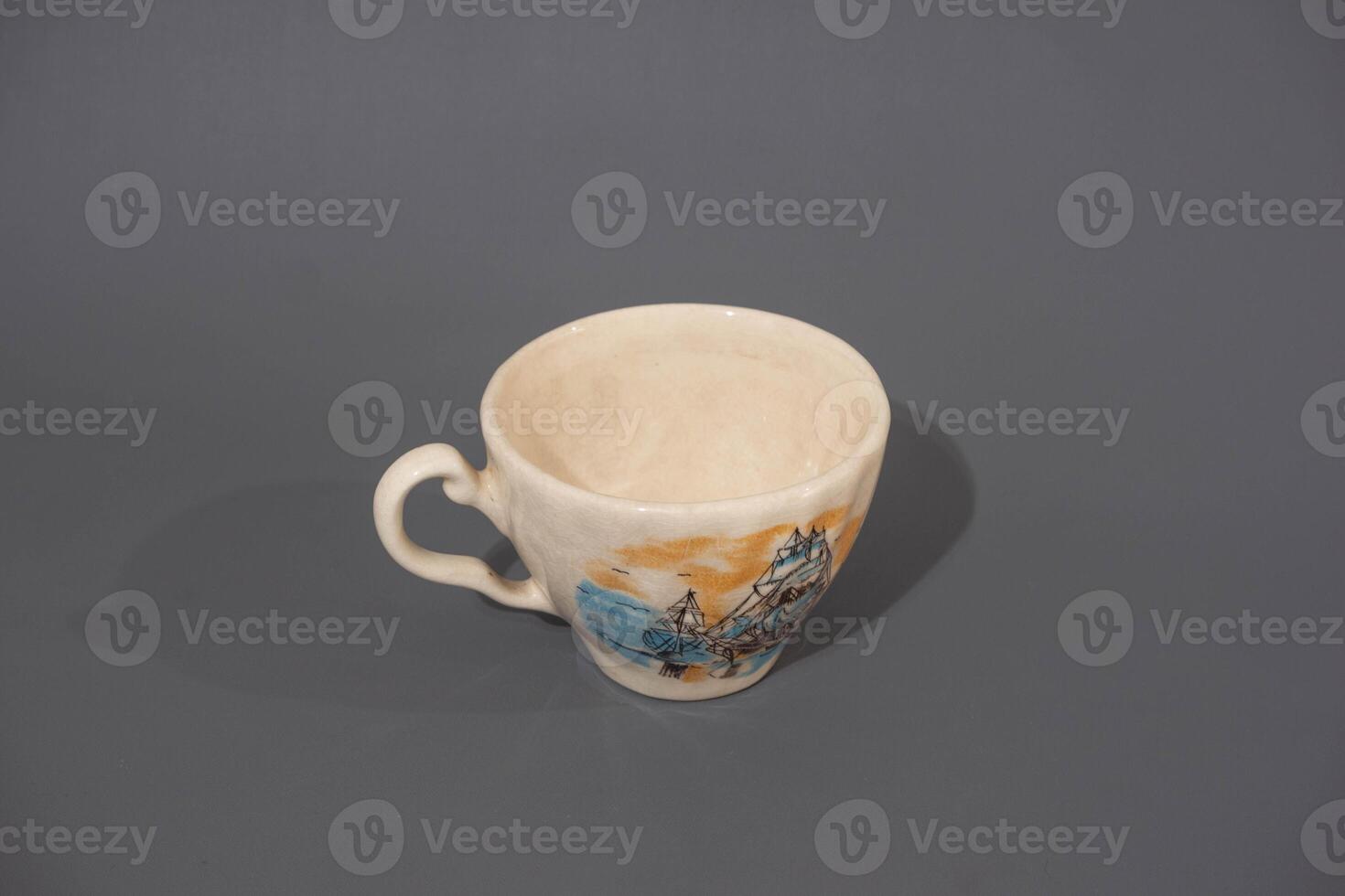 Ceramic cup with unique design isolated on grey background. Cooking utensil photo