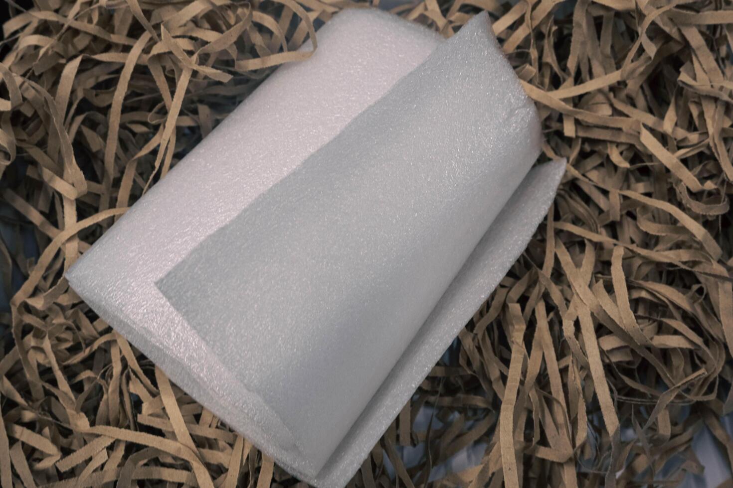 A roll of styrofoam on a piece of brown paper. photo