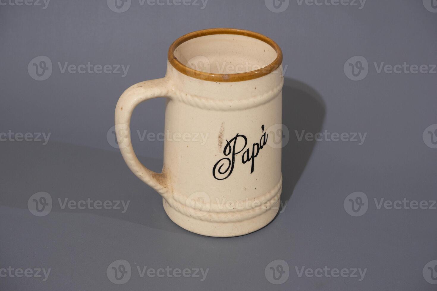 Ceramic teapot of cream colour and glass mug, unique design, kitchen utencil, isolated on grey background photo