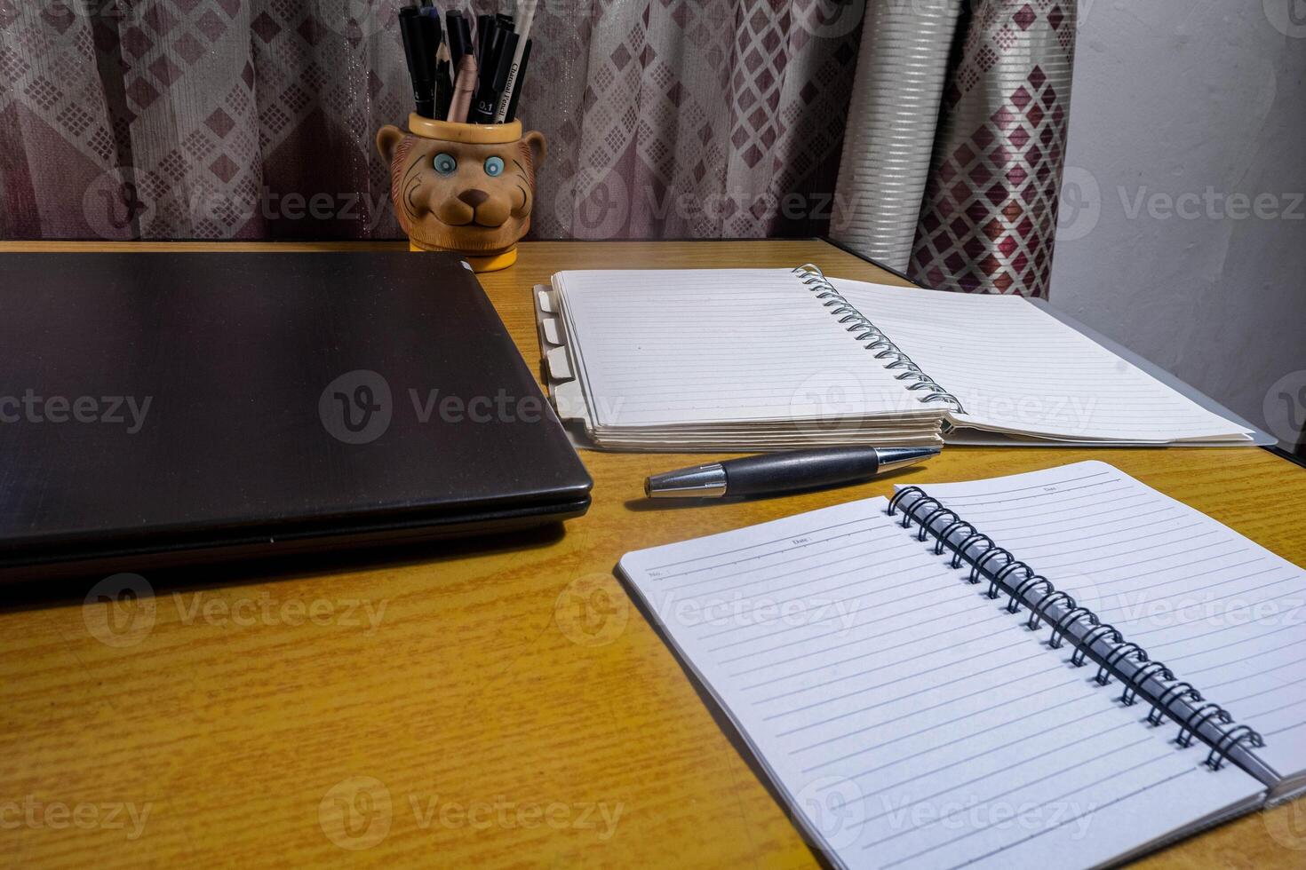 Office table with blank notebook, pen and laptop. office desk top view with blank notebook photo
