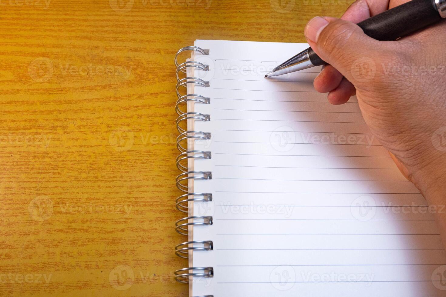 Hands holding pencils and notebooks. Hand with a pen is writing in a notebook. Mock-up Concept. photo