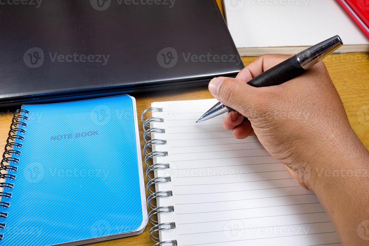 Hand with a pencil is writing in a notebook. hands holding pencils and notebooks. Mock-up Concept. photo
