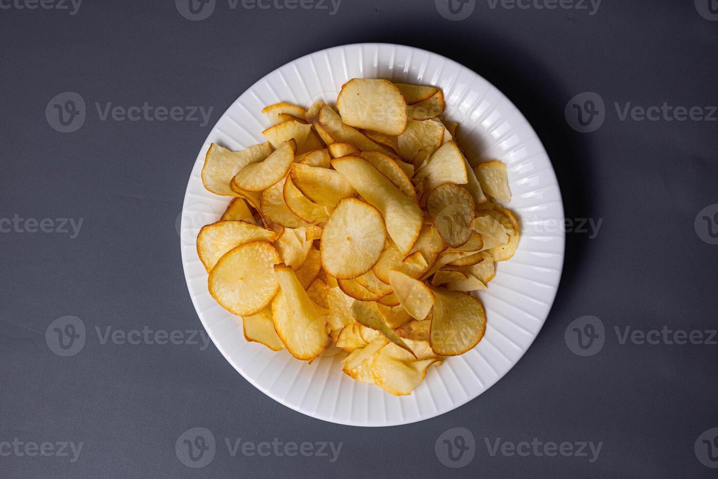Cassava Chips in grey background. Indonesian traditional snack. With copy space. Keripik Singkong photo
