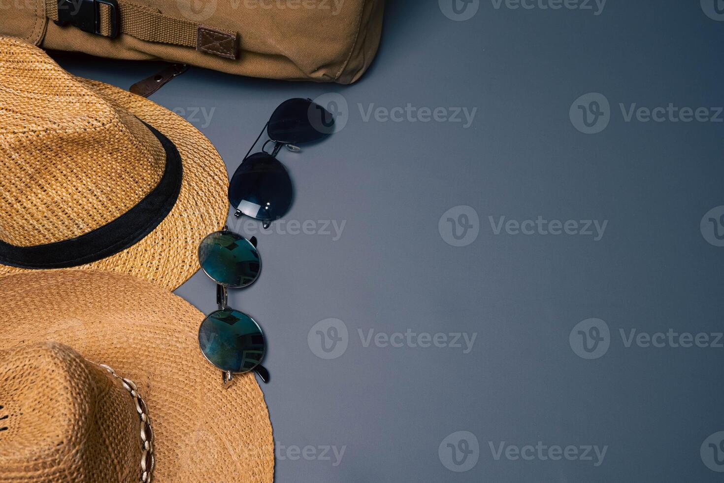 Two straw hats with two sunglasses on a gray background, summer beach fashion concept. Vacation, tourism photo
