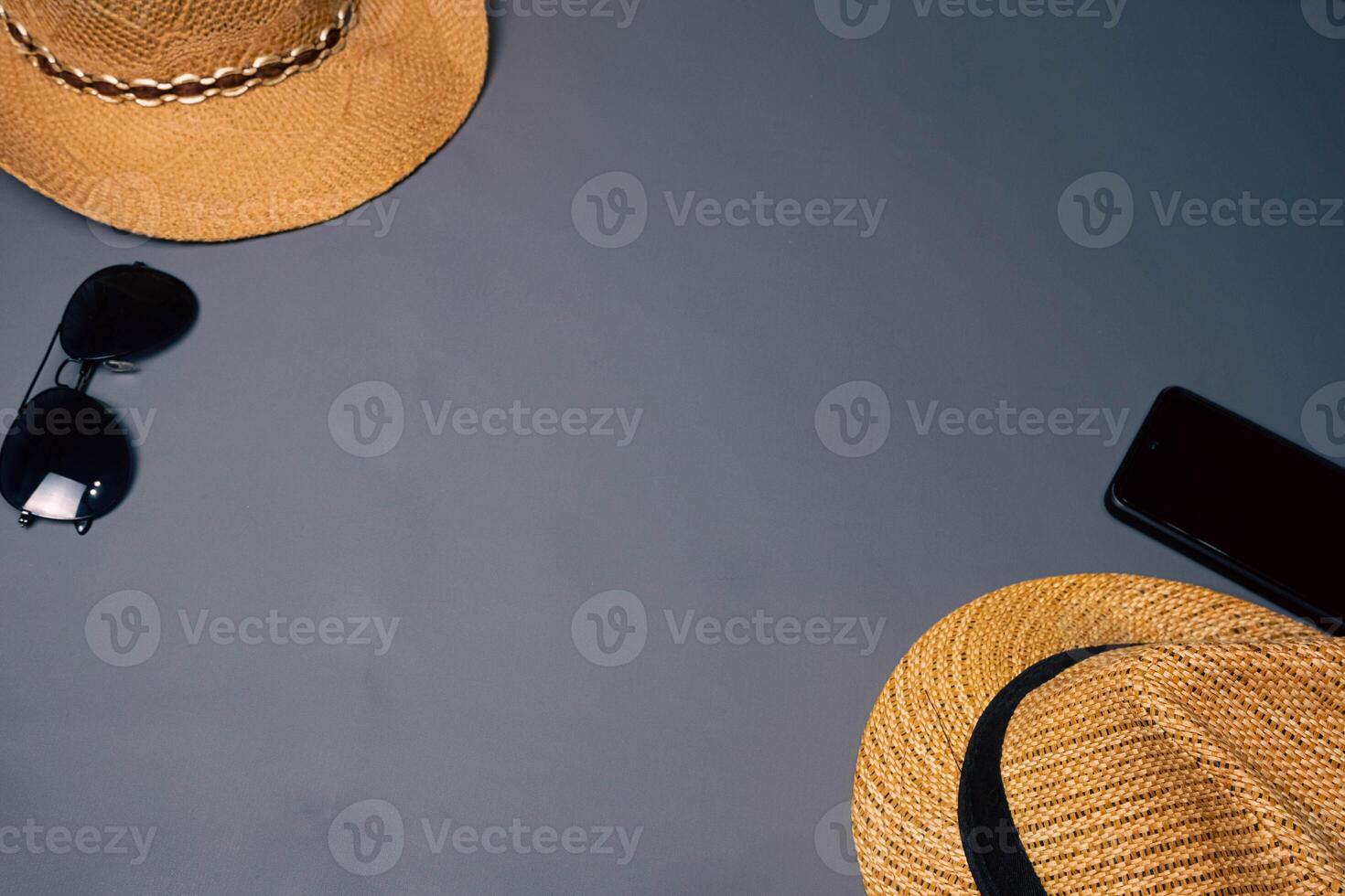 Two straw hats with two sunglasses on a gray background, summer beach fashion concept. Vacation, tourism photo