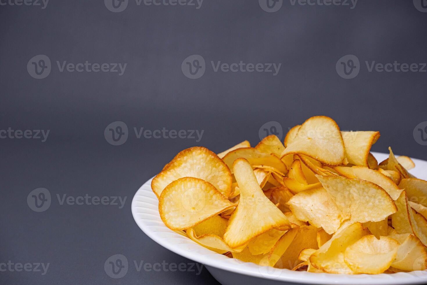 Cassava Chips in grey background. Indonesian traditional snack. With copy space. Keripik Singkong photo
