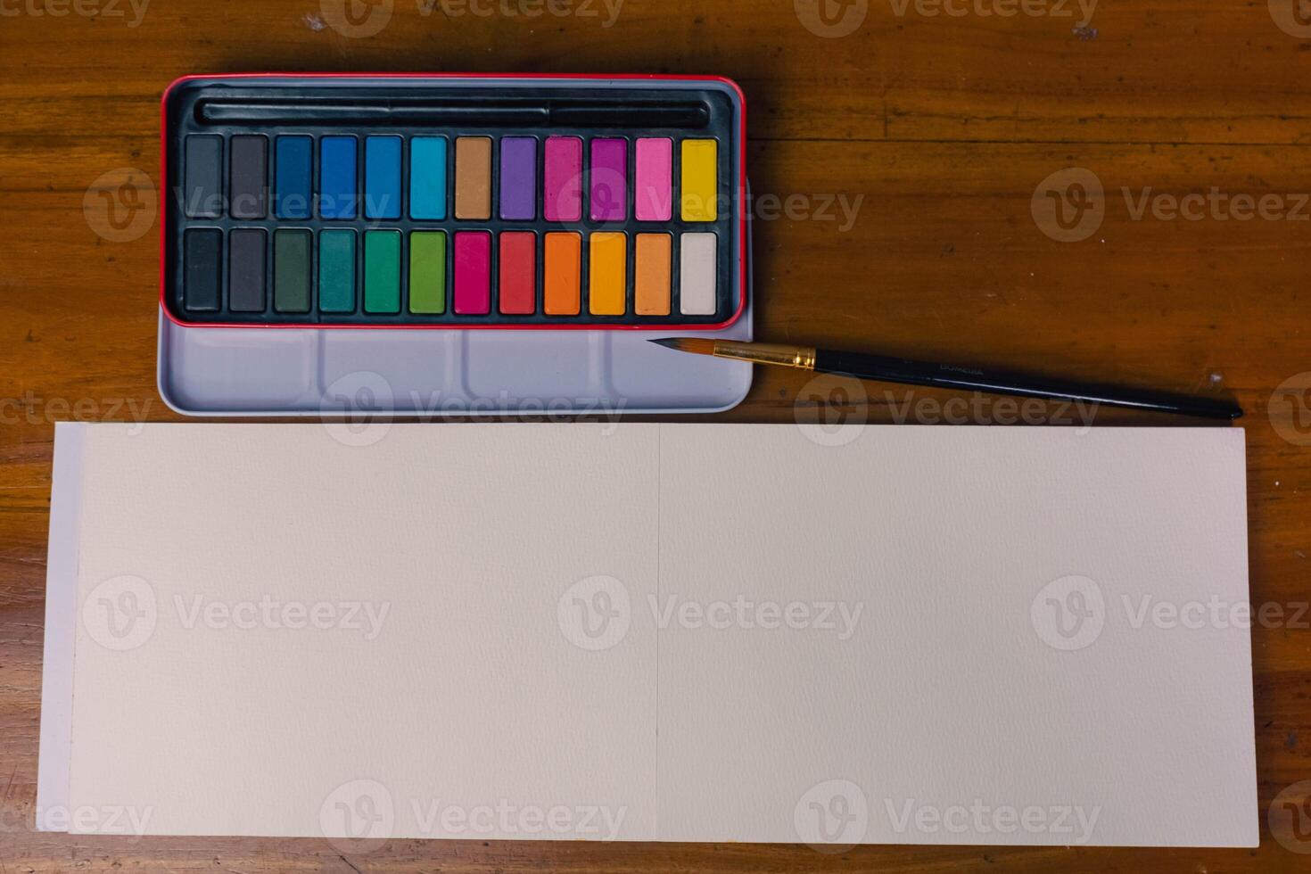 Blank sketchbook, color palette and a set brush, top view photo