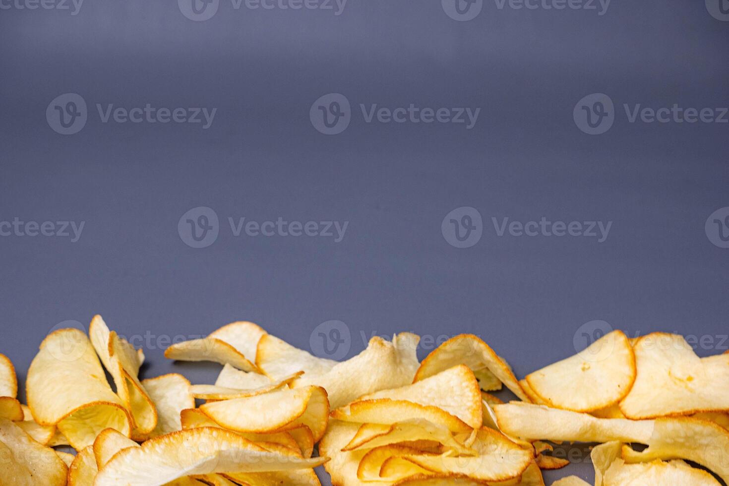 Cassava Chips in grey background. Indonesian traditional snack. With copy space. Keripik Singkong photo