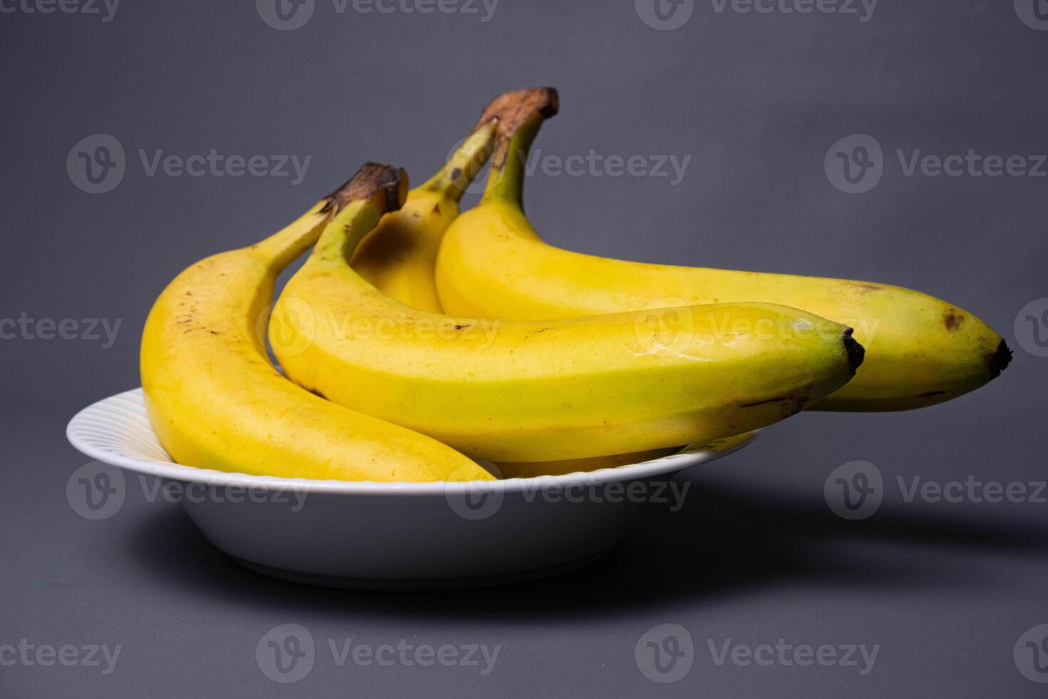 Delicious yellow fruit. Banana fruit isolated on gray background. Bunch of bananas. photo