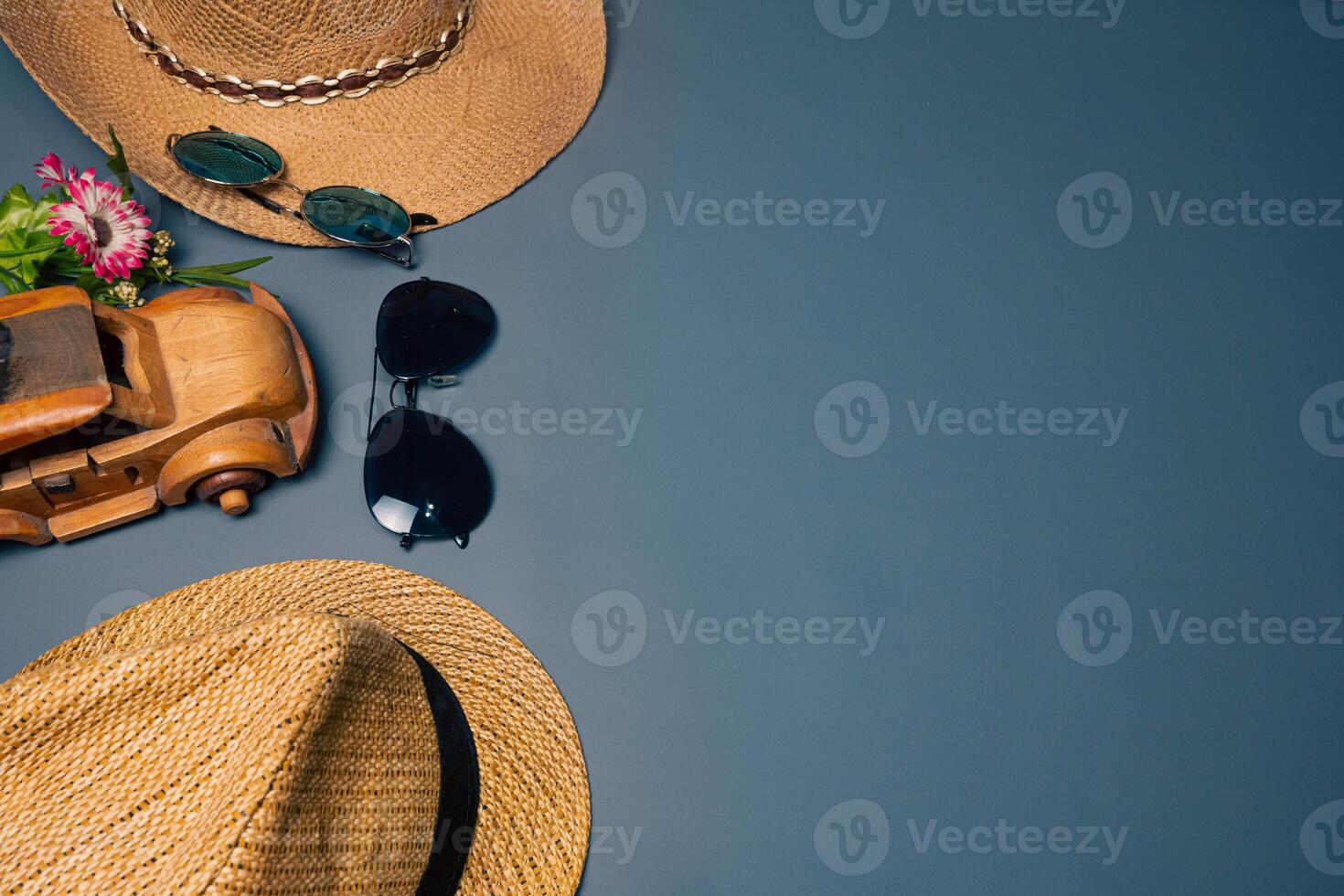 Two straw hats with two sunglasses on a gray background, summer beach fashion concept. Vacation, tourism photo