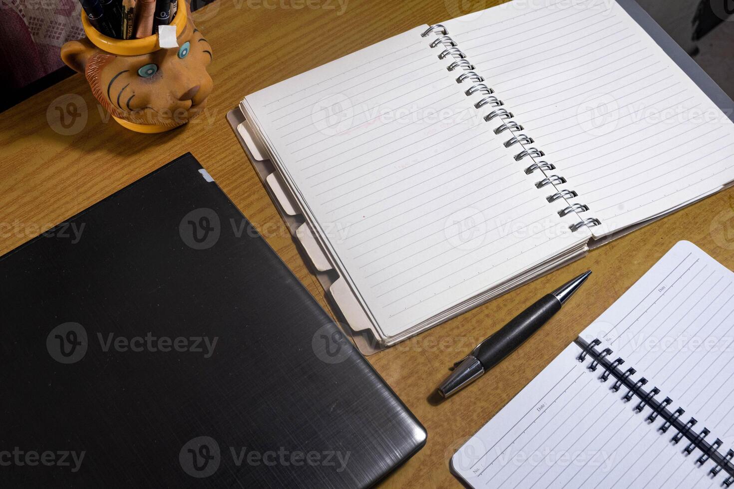 Office table with blank notebook, pen and laptop. office desk top view with blank notebook photo