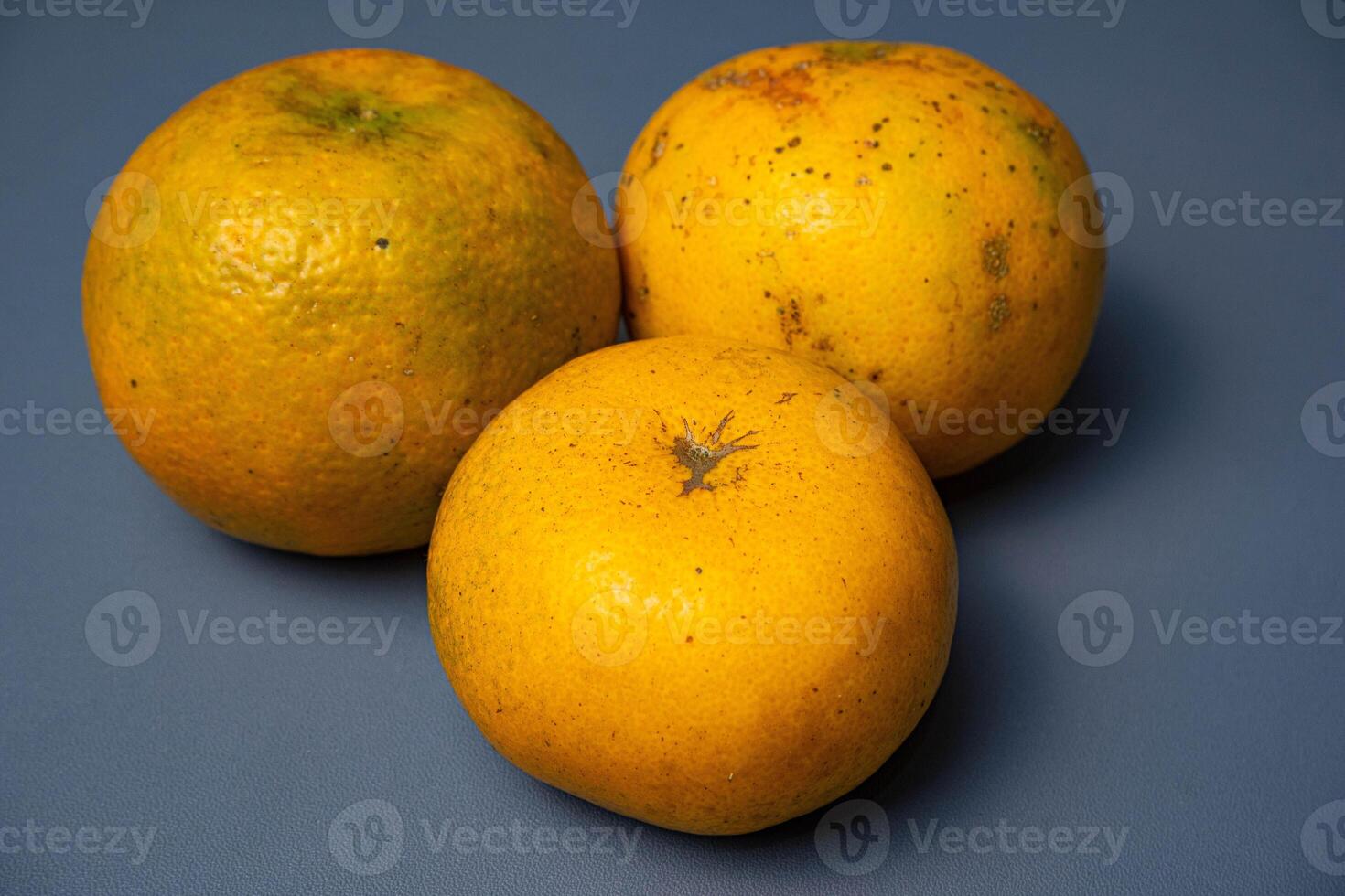 Three oranges on grey background. photo