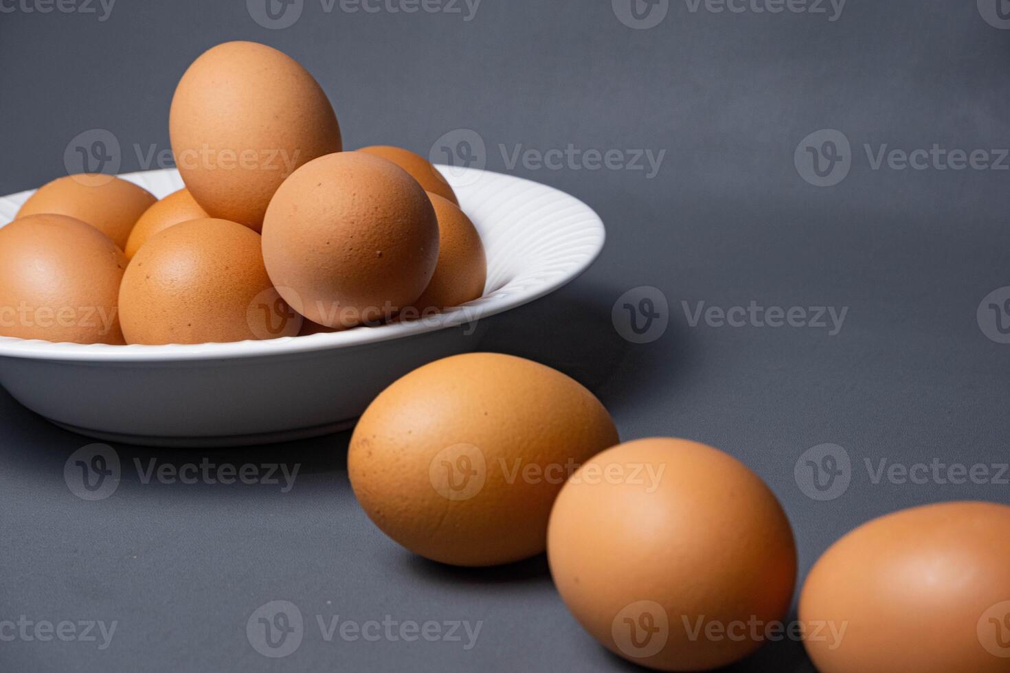 Chicken eggs arranged on a white plate on a black background. photo