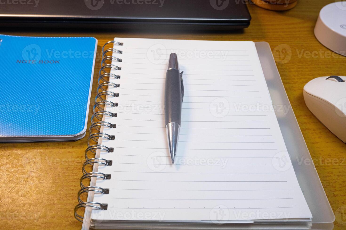 Office table with blank notebook, pen and laptop. office desk top view with blank notebook photo