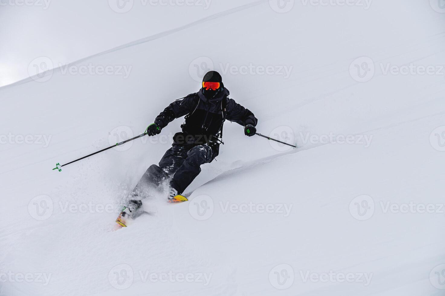 Skier man in action. Front view. Fast descent at high speed. Skier on skis in high mountains. Descent. Skiing in the mountains. Snow dust photo