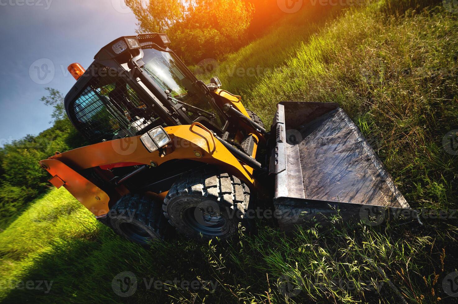 Excavator against the background of a green field and trees. Wide angle shooting photo