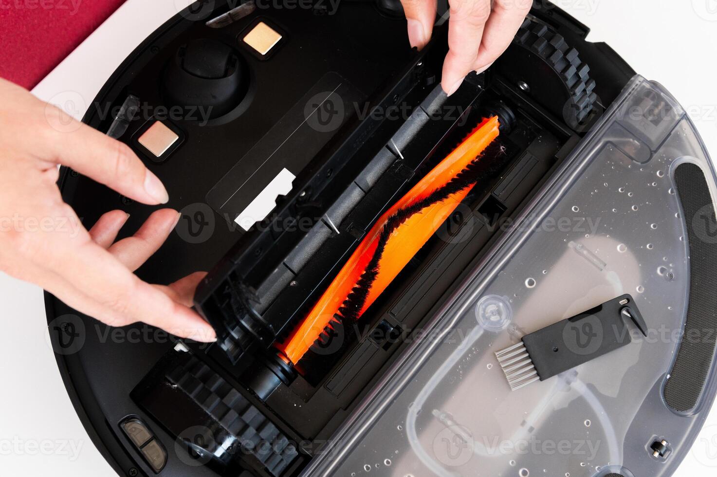 The hands of a Caucasian young woman are cleaned by a robot vacuum cleaner. An overturned vacuum cleaner on the table. Service photo