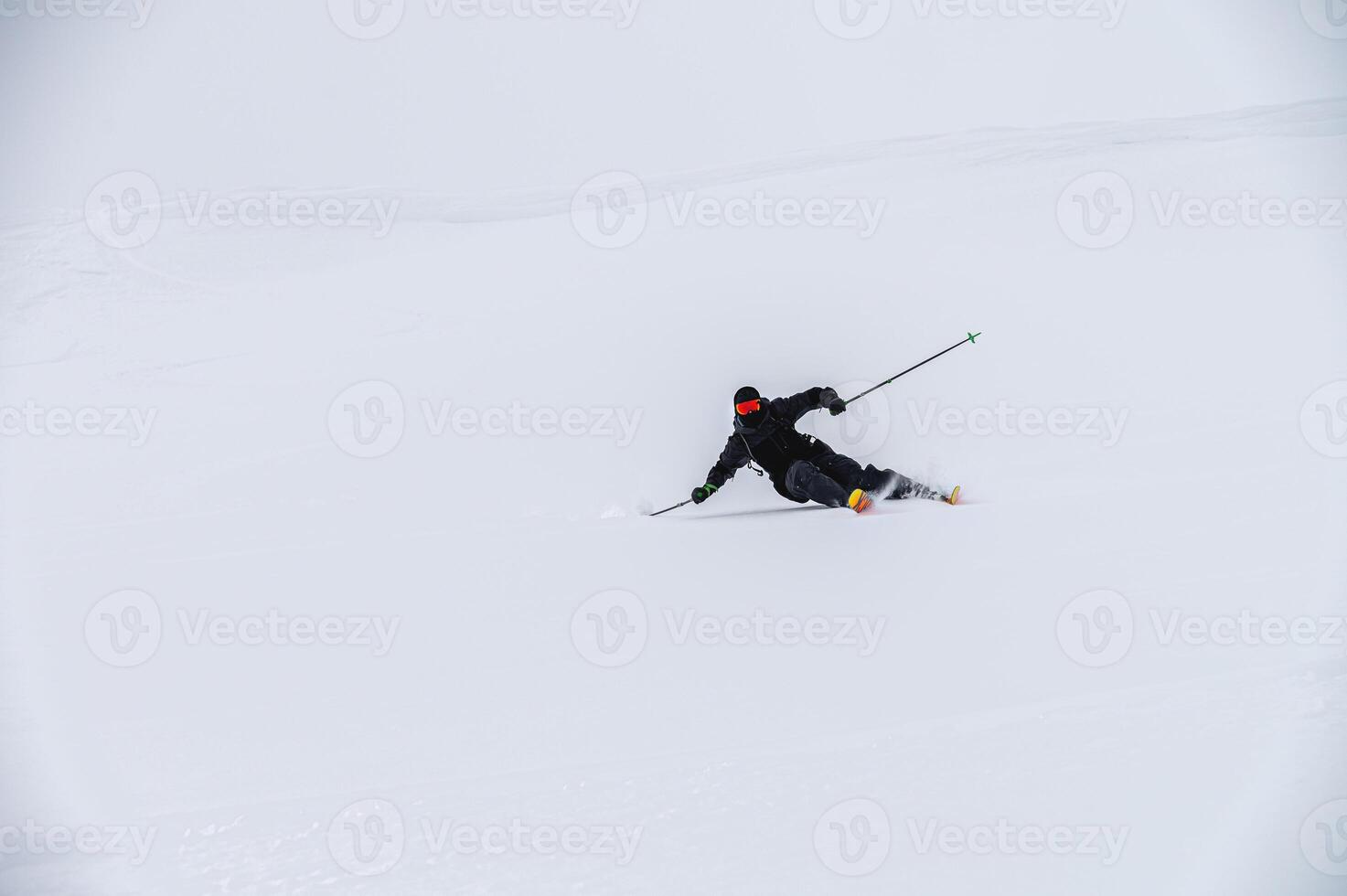 Skier man in action. Front view. Fast descent at high speed. Skier on skis in high mountains. Descent. Skiing in the mountains. Snow dust photo