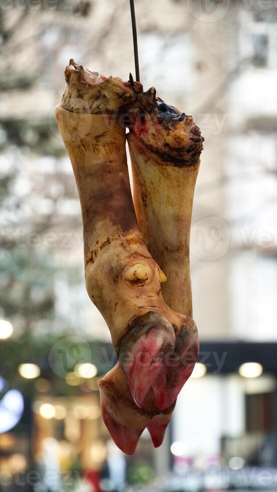 Butchered Animal Legs Hanging in Market photo