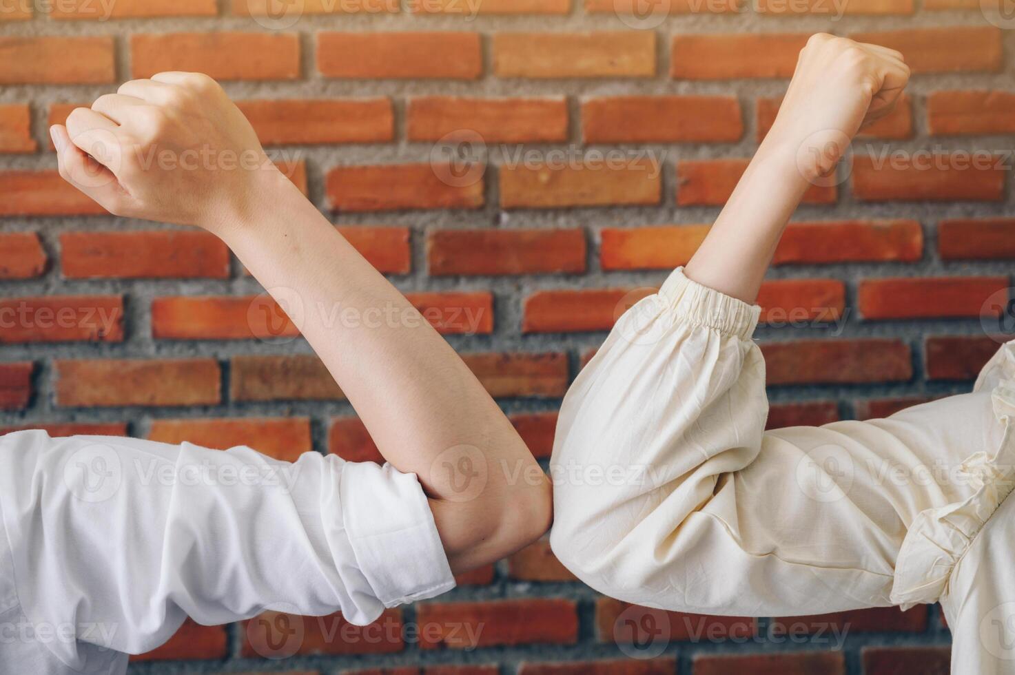 Cropped shot of two women bump elbows for greeting during coronavirus epidemic. photo