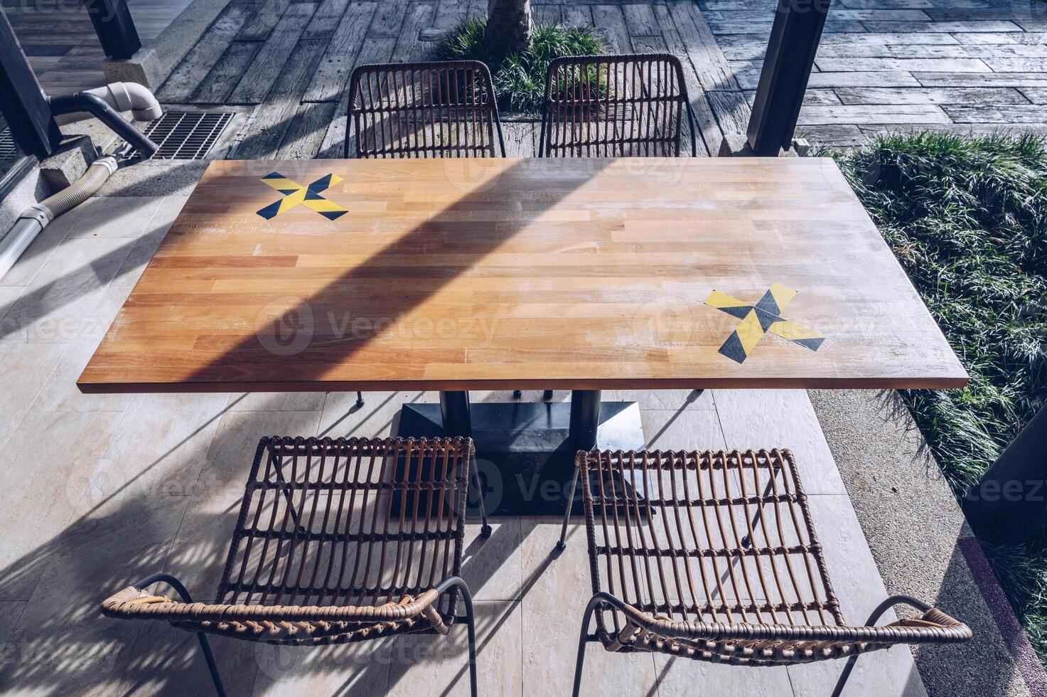 The marking on empty wooden table without nobody. Keep spaced between each chairs make separate for social distancing to avoid spreading of Covid-19. Social distance concept. photo