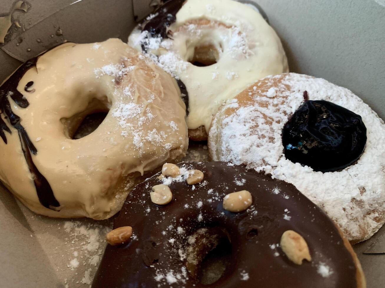 a box of donuts with powdered sugar and chocolate. photo