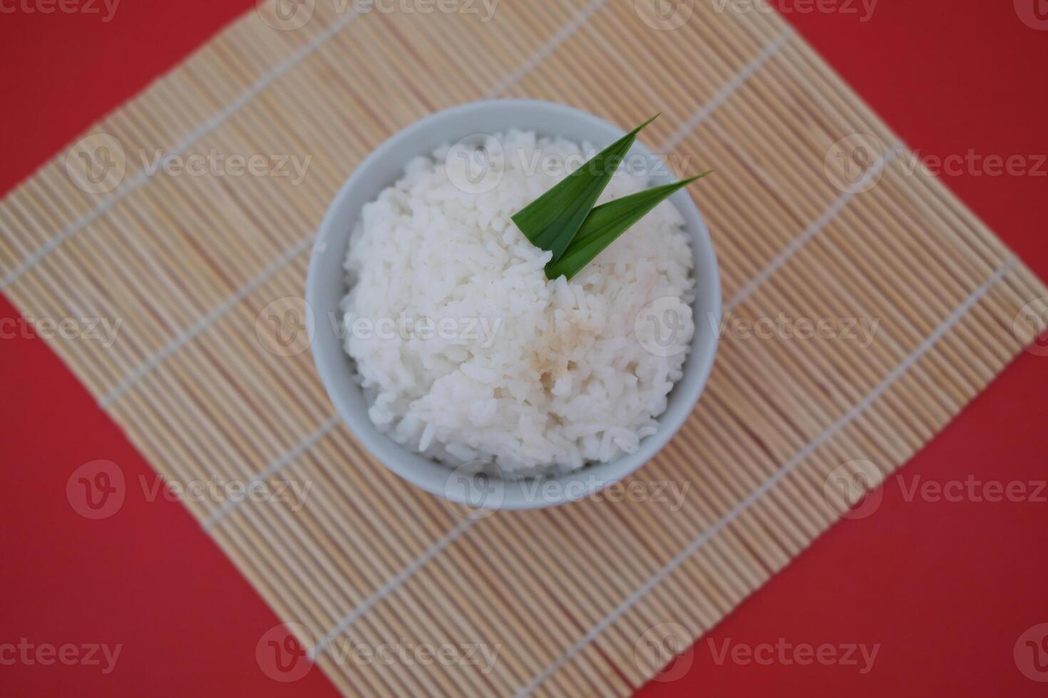 Cooked rice in a bowl with red background, top view. photo