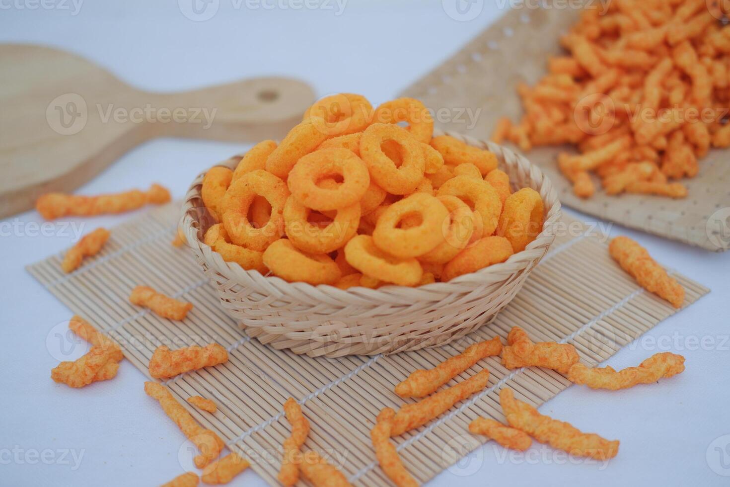 snack cheese crackers in a basket on bamboo mat with white background. photo