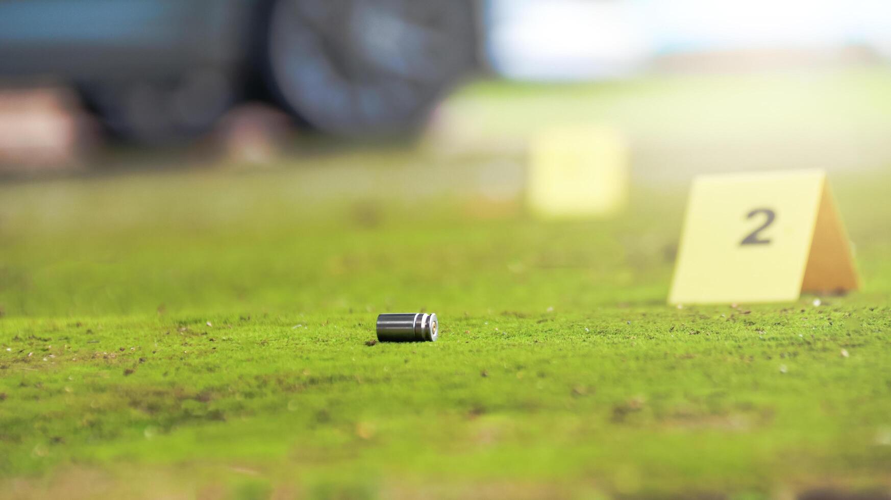 Spent bullet casing lying on the ground with blur number 2 sign. Concepts of shooting sports and security highlighting the dual nature of firearms in both competitive sport and protective measures. photo