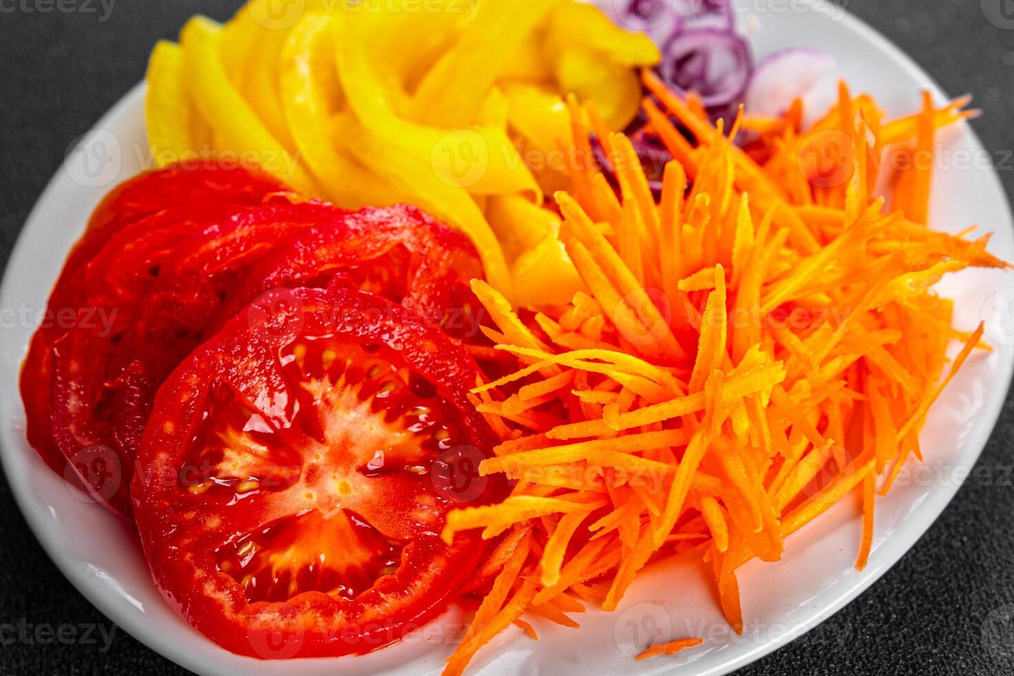 salad fresh vegetables cut into a plate tomato, carrot, pepper, onion juicy fresh gourmet food background on the table rustic food top view copy space keto and paleo diet Vegetarian and vegan photo