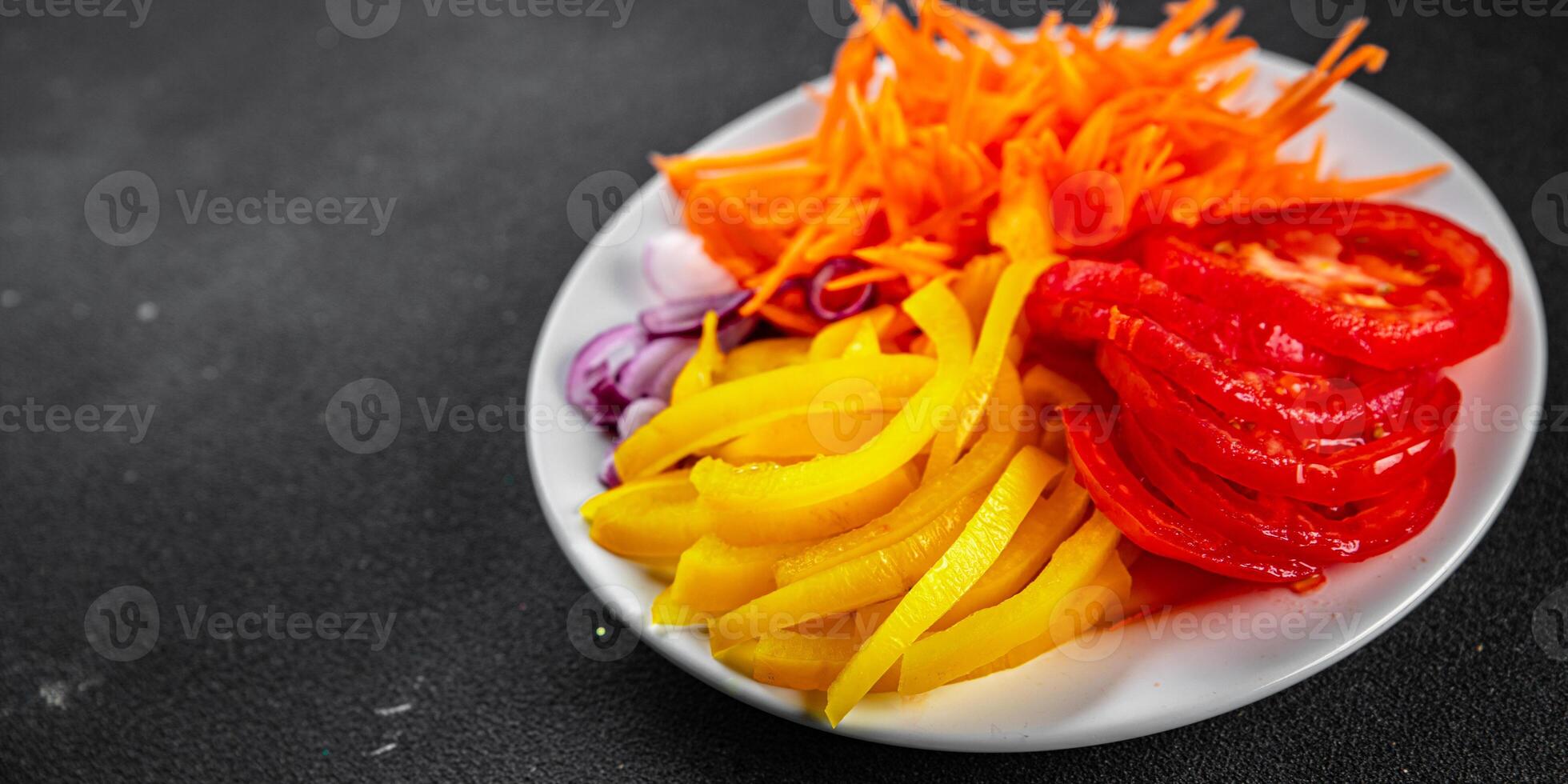salad fresh vegetables cut into a plate tomato, carrot, pepper, onion juicy fresh gourmet food background on the table rustic food top view copy space keto and paleo diet Vegetarian and vegan photo