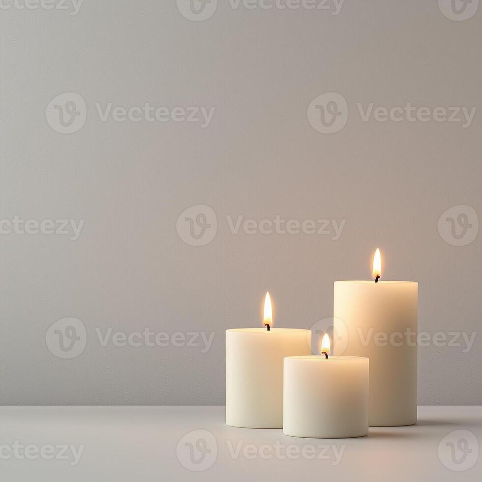 White candles burning softly against a neutral background in a minimalist composition photo