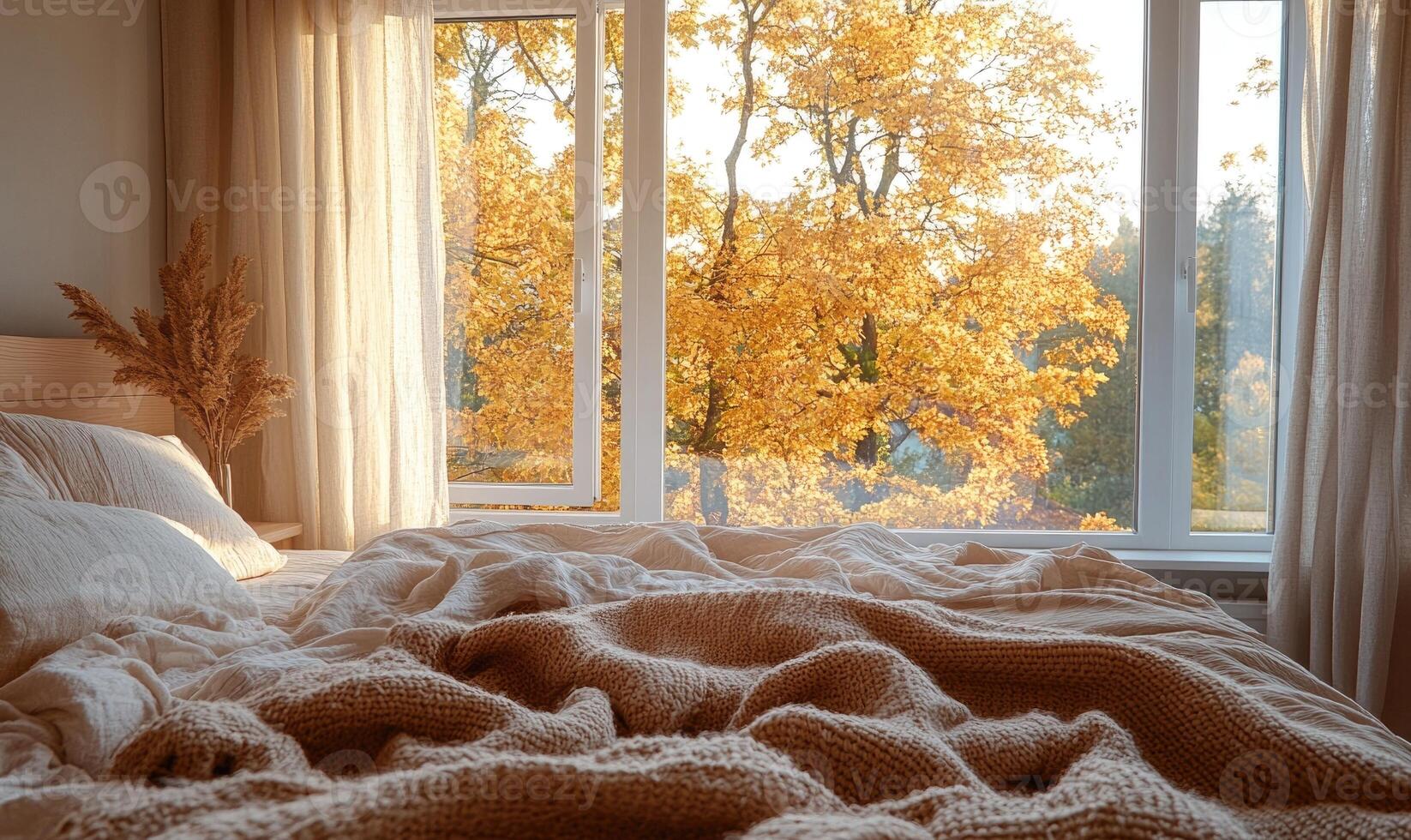 Bright bedroom with light wood bed, warm blankets, panoramic windows and autumn decor photo