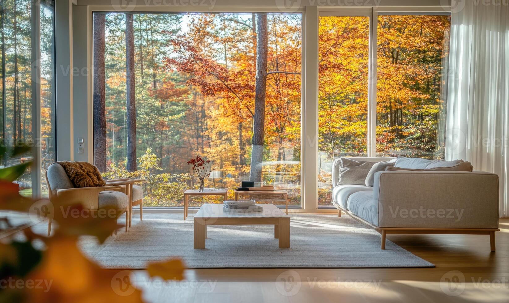 Bright living room with light wood bed, panoramic windows and golden autumn forest outside photo