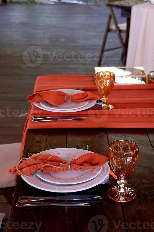 Table setting with orange napkins and glasses. Classic. Warm shades photo