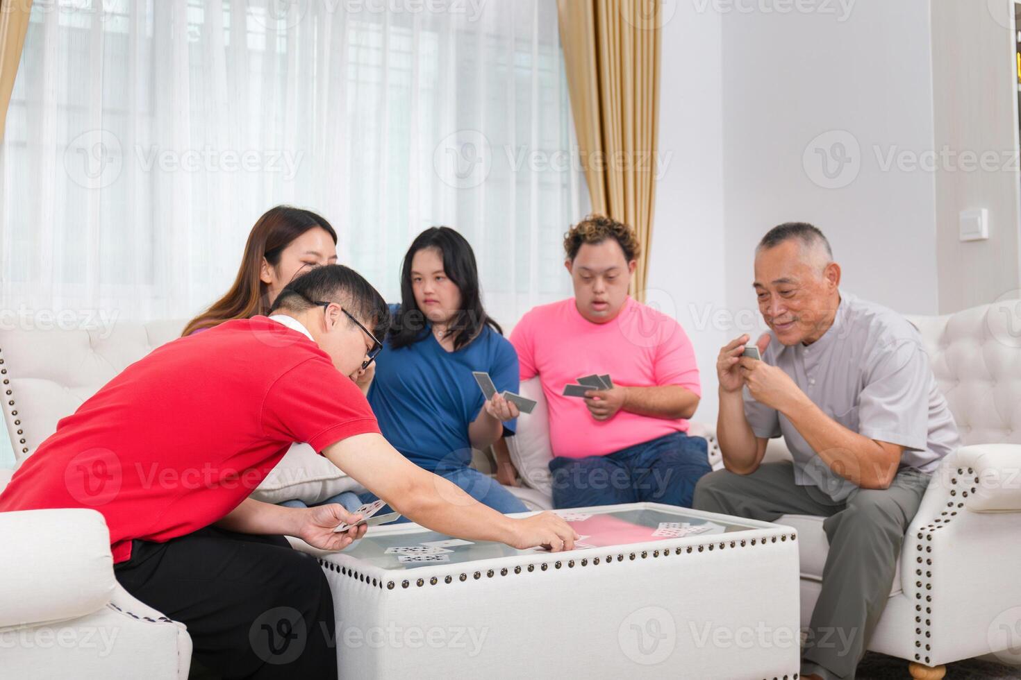 Grandchild interacting with friends and playing cards with grandparents at home photo