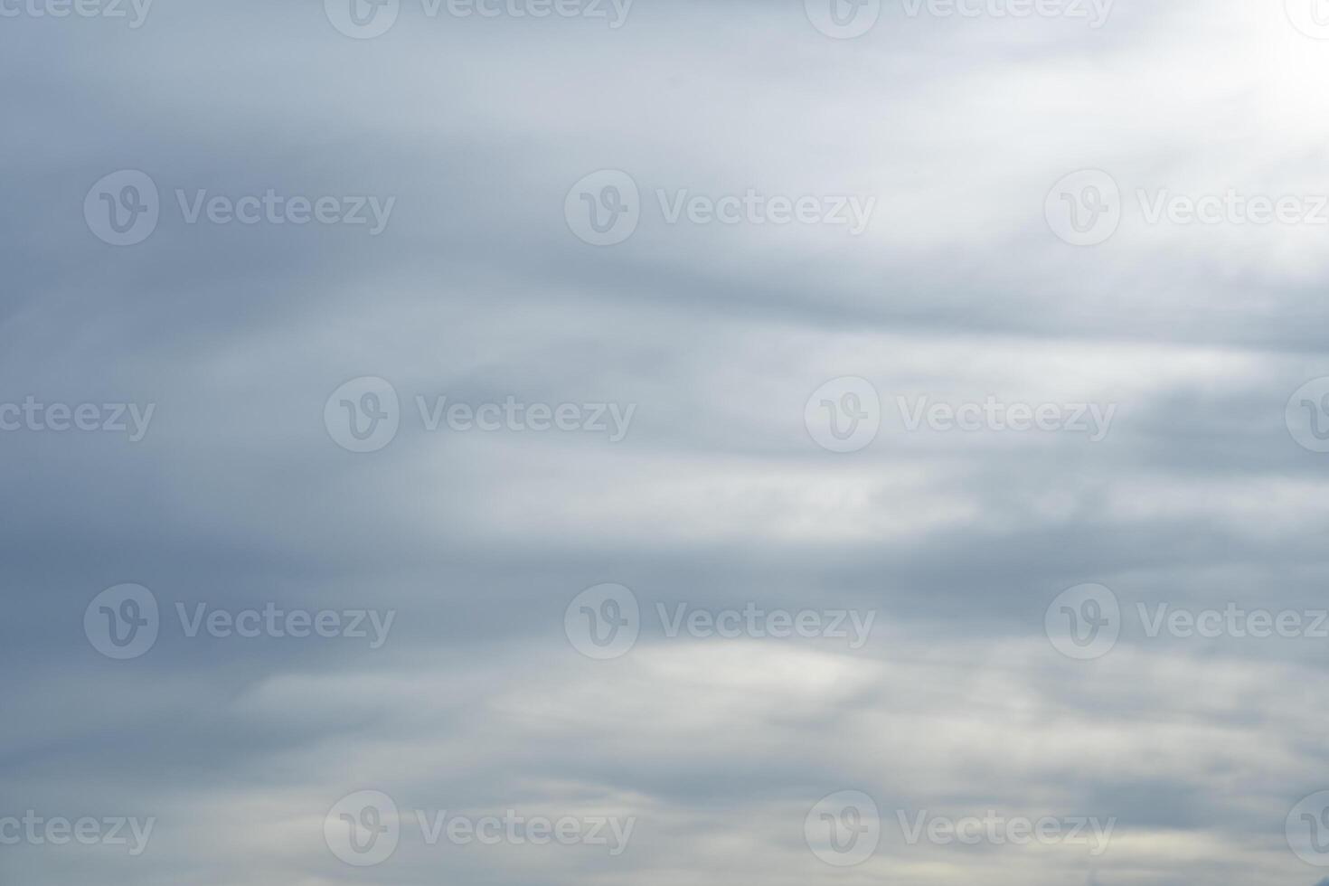 Dramatic rain clouds sky background. Gray clouds in the sky blocking the sun. Rain storm cumulus clouds with beautiful light. photo