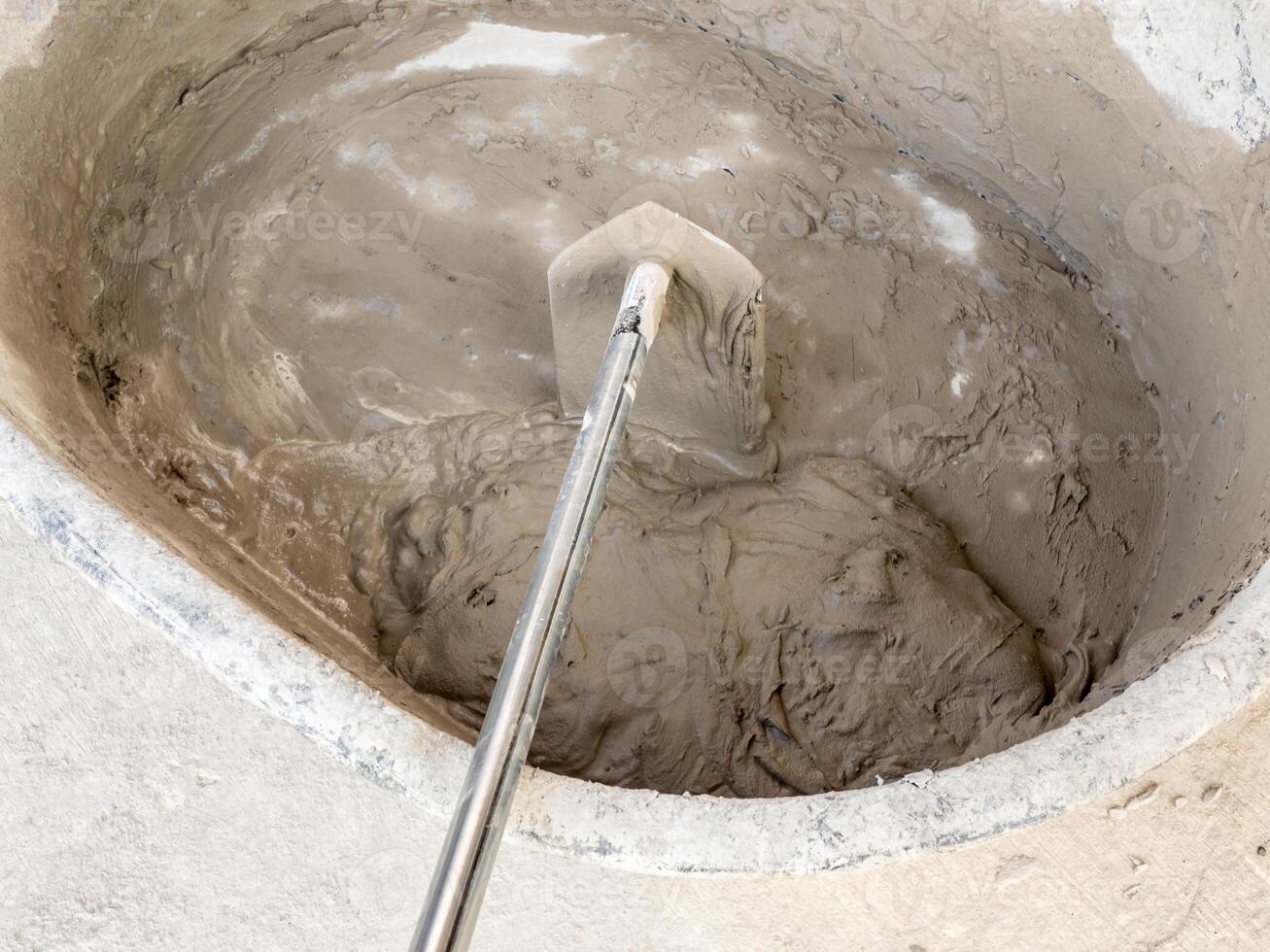Concrete is mixed in a concrete mixing bowl photo