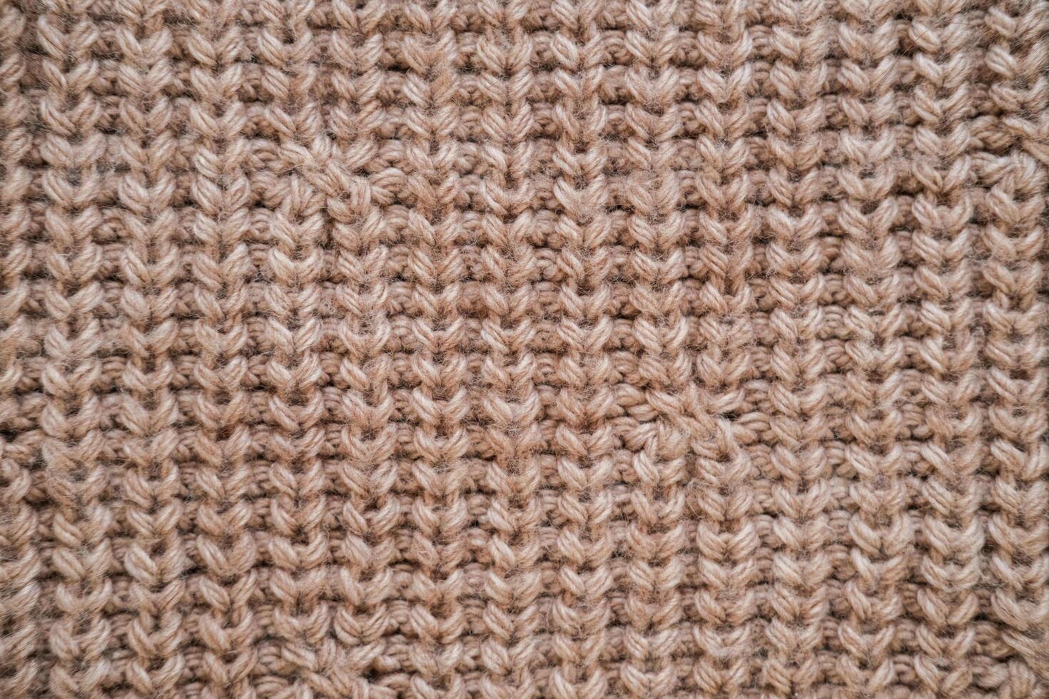 Close-up of the texture of knitted woolen fabric in light brown color photo