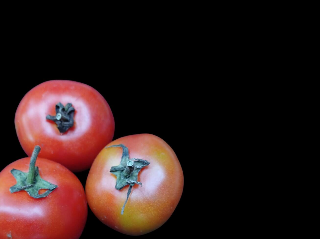 Set of red tomato vegetable fruits on black background good for food. photo