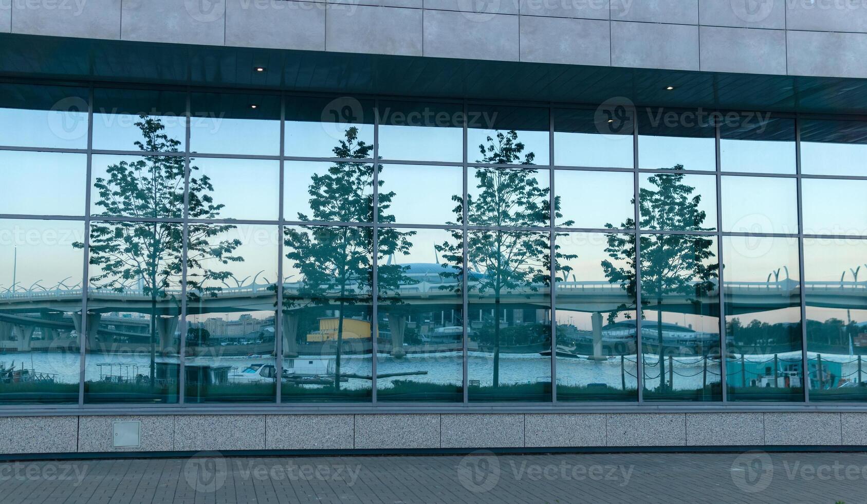 modern architecture, glass facade element with evening cityscape reflection photo