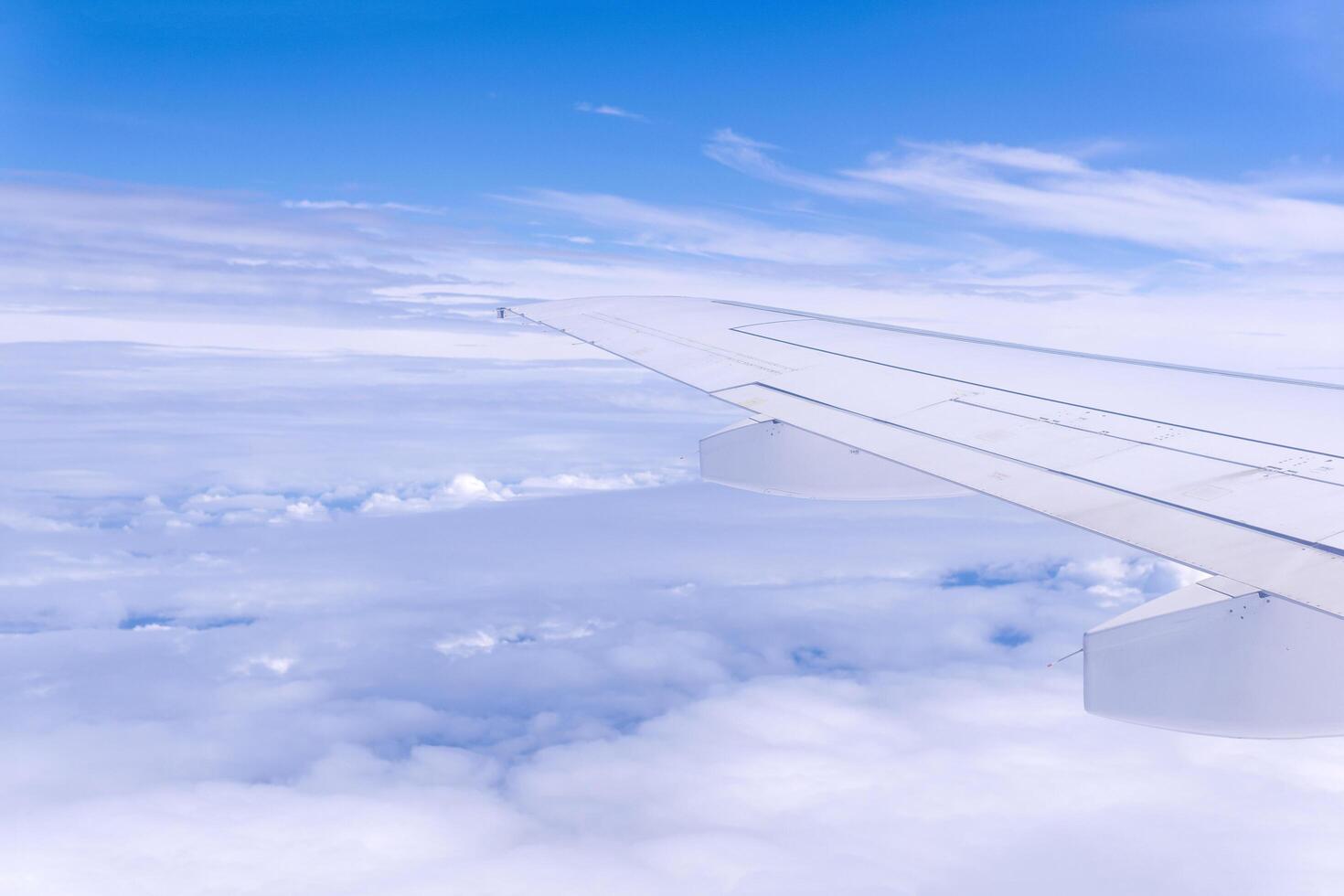 view from airplane window during flight, wing and cloudscape, view above clouds photo