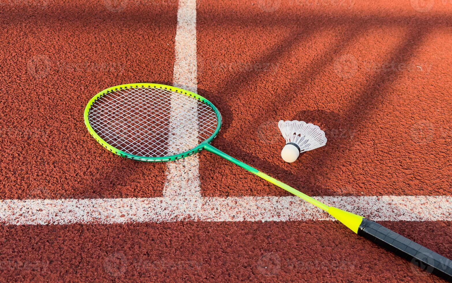 Cream white badminton shuttlecock and racket on badminton court, copy space, soft and selective focus. photo