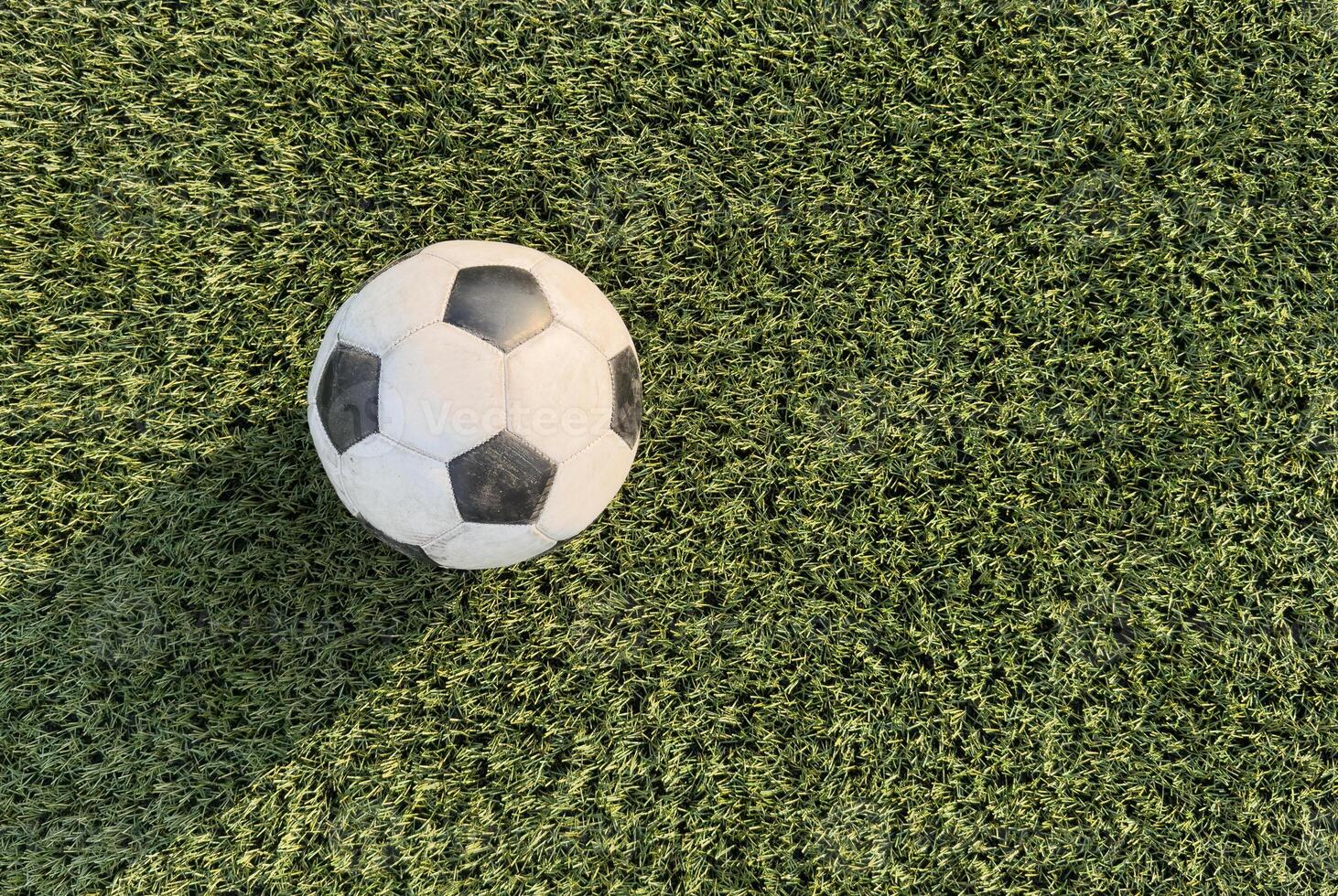 top view of football on green field, soccer ball on grass photo