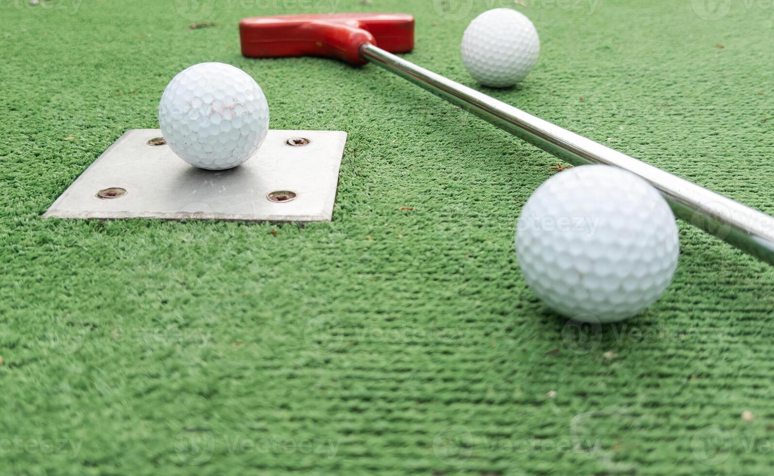 Fun vacation entertainment for summertime. Playing mini golf on green grass outdoors. Setting goals and winning lifestyle concept. Competition at golf course. two crossed sticks. Blank space for copy. photo