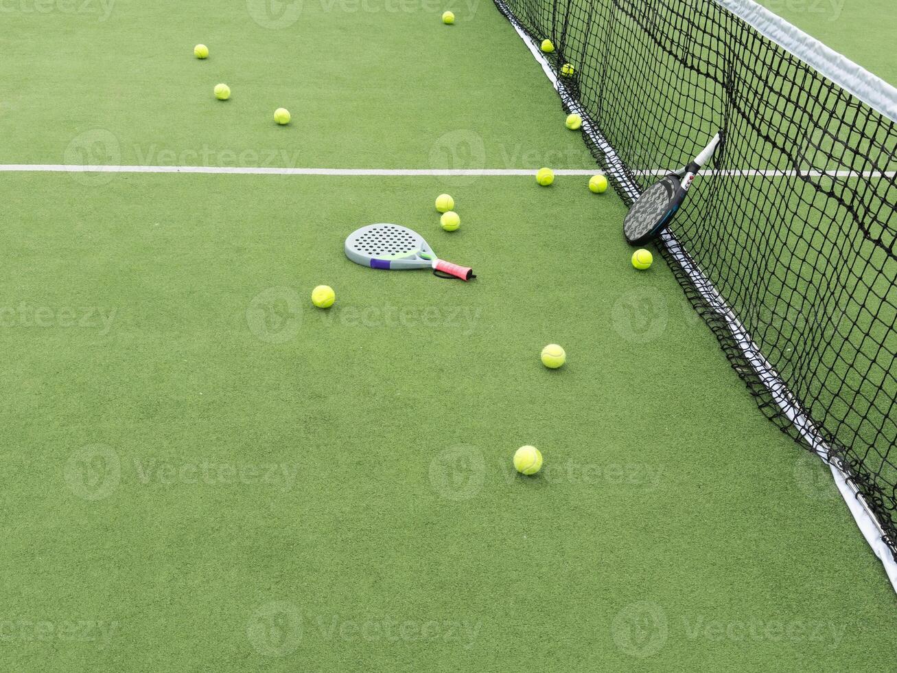paddle tennis objects in court, racket and balls photo