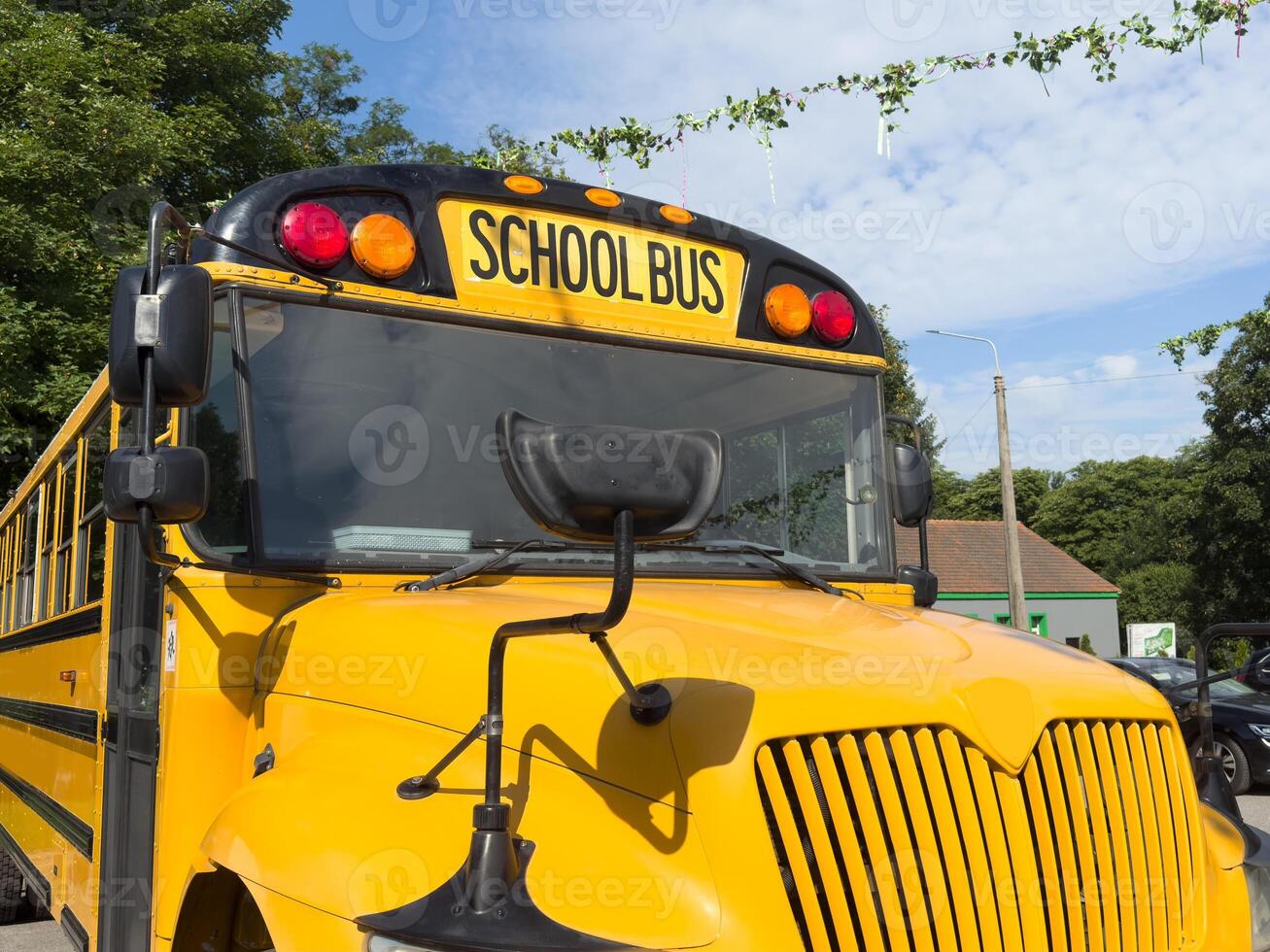 Shot of retro-styled yellow school bus with extended red stop sign standing still on serene road, empty vehicle with no driver awaiting children to boarding, transportation concept, copy space photo