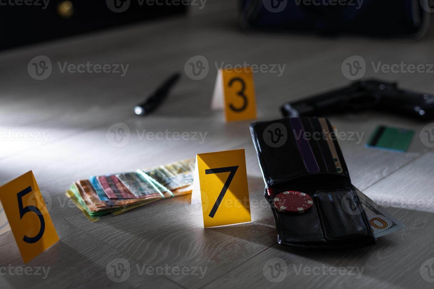 Crime scene investigation - numbering of evidences after the murdering in apartment. Brass knuckle, wallet and clothes with evidence markers photo