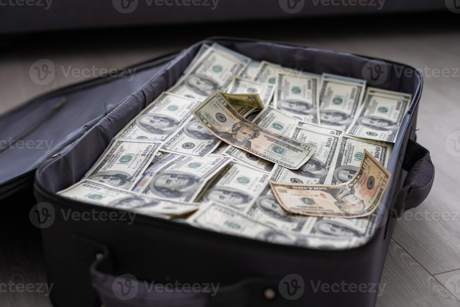 an old black suitcase with an open lid full of one hundred dollar bills. Corruption photo