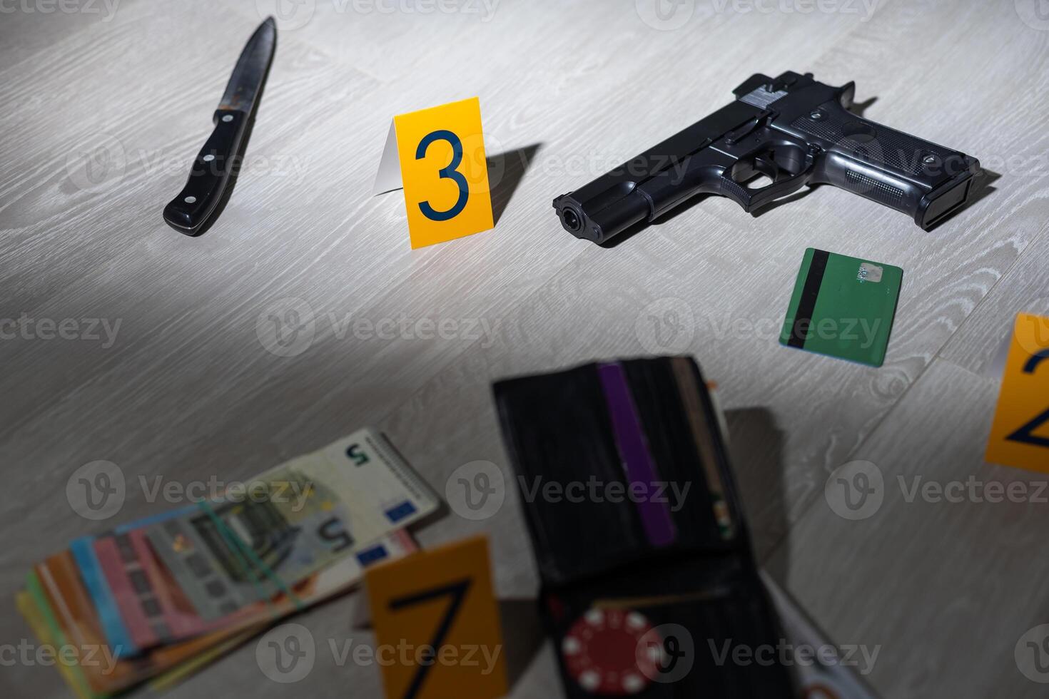 High contrast image of a crime scene with gun and markers on the floor photo